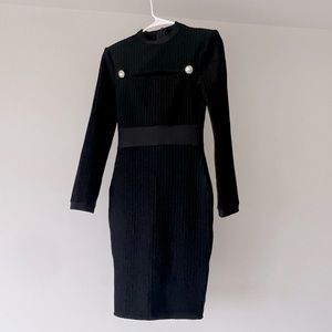 Knee length long sleeve cut out dress in black.